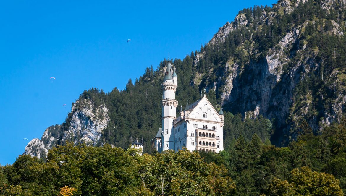 Blick auf Schloss Neuschwanstein mit Gleitschirmfliegern