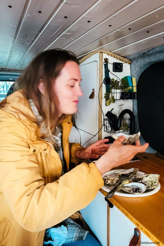 Schnappschuss: Frau isst in ausgebautem Bus eine Auster von Wheelers Oyster Bar