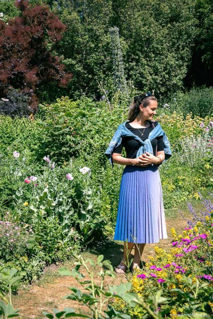 Frau im Rock steht in den Gärten von Highdown Gardens