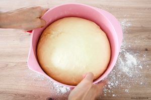 Fertig aufgegangener Hefeteig mit deutlich verdoppeltem Volumen in einer pinken Schüssel