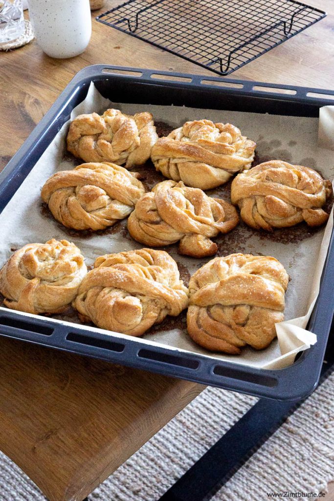 Kardamom Knoten backen: Gebäck auf schwarzem Blech
