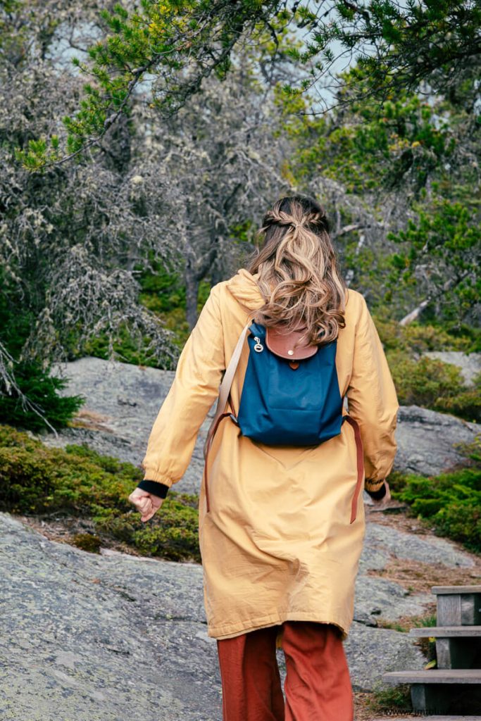 Zimtblume geht in einer gelben Jacke auf der Pointe de l'Islet in Tadoussac spazieren